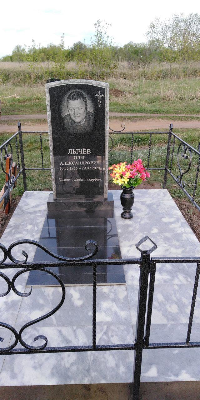 Одиночный гранитный памятник на светлом подиуме.